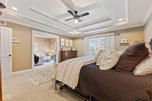 bedroom with a raised ceiling, ornamental molding, ceiling fan, and light colored carpet