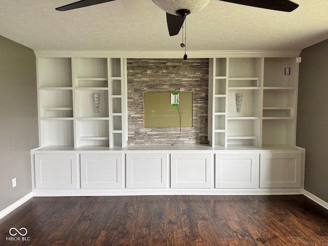 unfurnished living room with dark hardwood / wood-style flooring, ceiling fan, and a textured ceiling