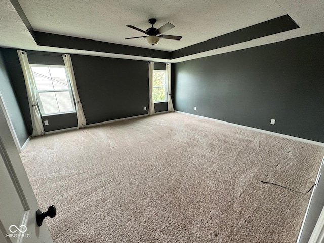 empty room featuring carpet, a wealth of natural light, and ceiling fan