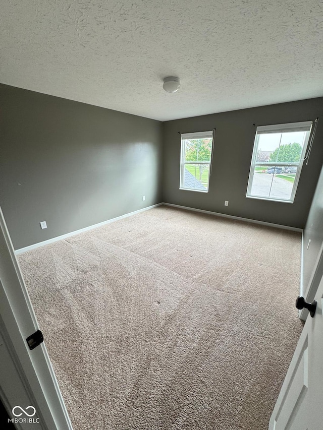 carpeted spare room featuring a textured ceiling