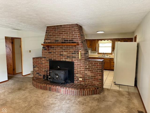 unfurnished living room featuring a textured ceiling, sink, and light carpet