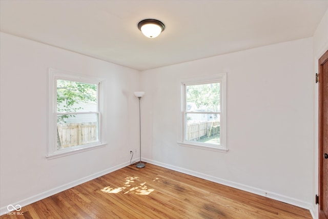 spare room featuring a healthy amount of sunlight and hardwood / wood-style floors