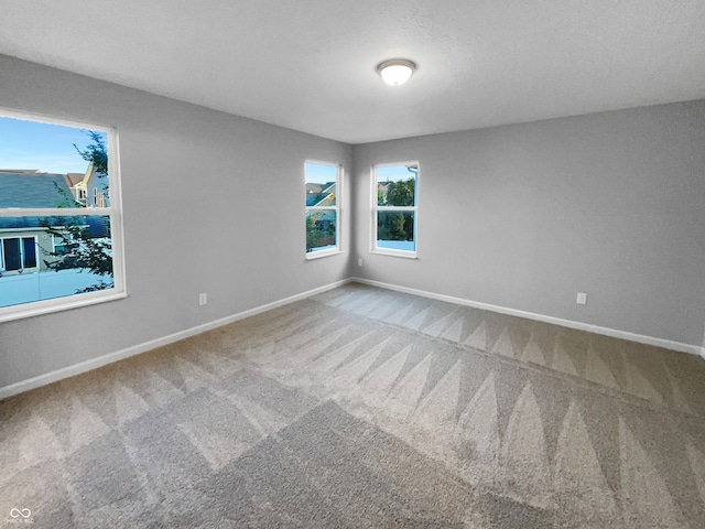 carpeted empty room featuring a textured ceiling