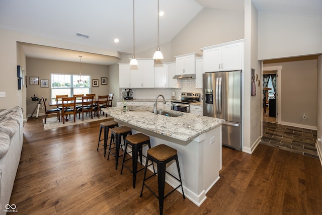 1569 Tupelo Dr, Greenfield, IN 46140 - kitchen featuring stainless steel appliances, a sink, under cabinet range hood, a kitchen bar, and white cabinetry