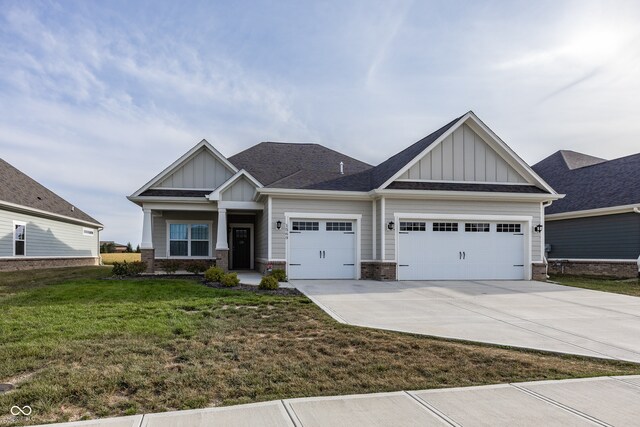 1569 Tupelo Dr, Greenfield, IN 46140 - craftsman-style home with board and batten siding, an attached garage, driveway, a front lawn, and brick siding