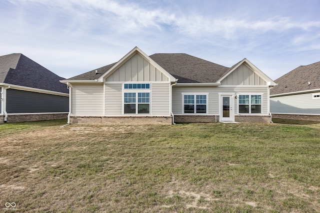 1569 Tupelo Dr, Greenfield, IN 46140 - back of house with board and batten siding, a lawn, and brick siding