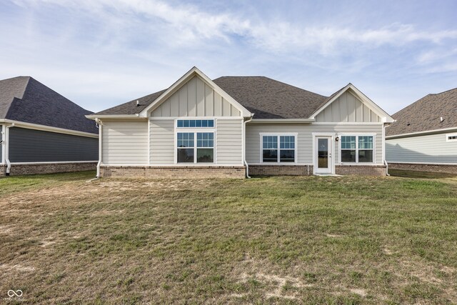 1569 Tupelo Dr, Greenfield, IN 46140 - back of house with board and batten siding, a lawn, and brick siding