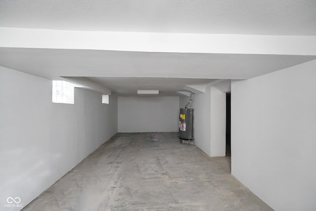 basement with electric water heater and a textured ceiling