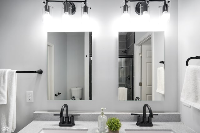 bathroom featuring vanity, toilet, and an enclosed shower