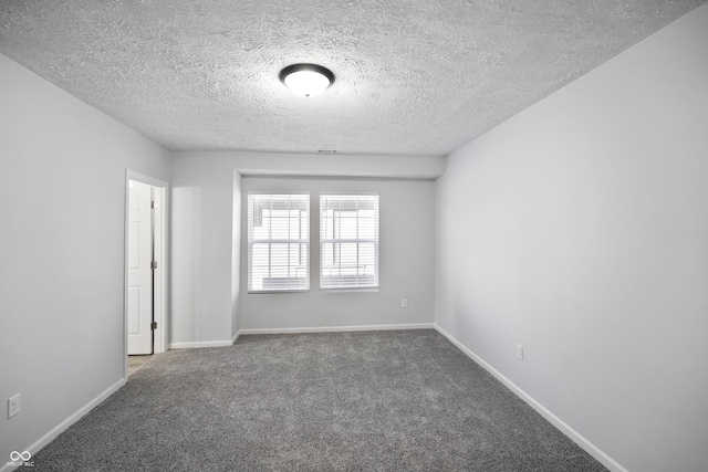 carpeted empty room featuring a textured ceiling