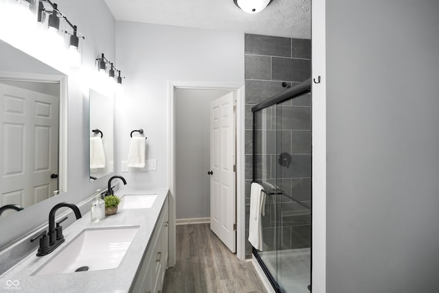 bathroom featuring vanity, a textured ceiling, hardwood / wood-style flooring, and an enclosed shower