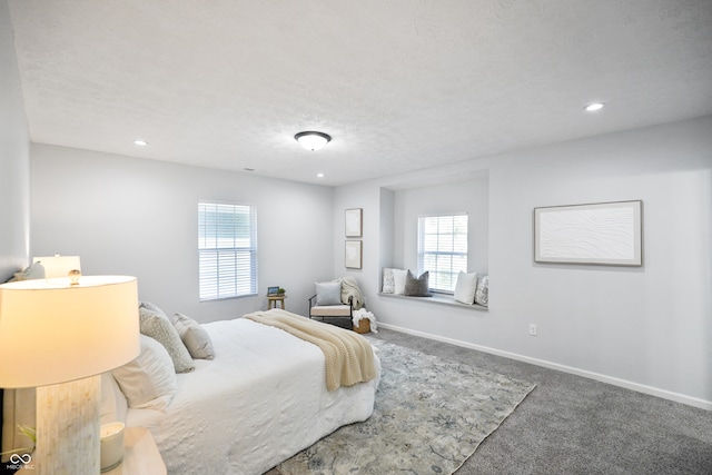 carpeted bedroom featuring multiple windows and a textured ceiling