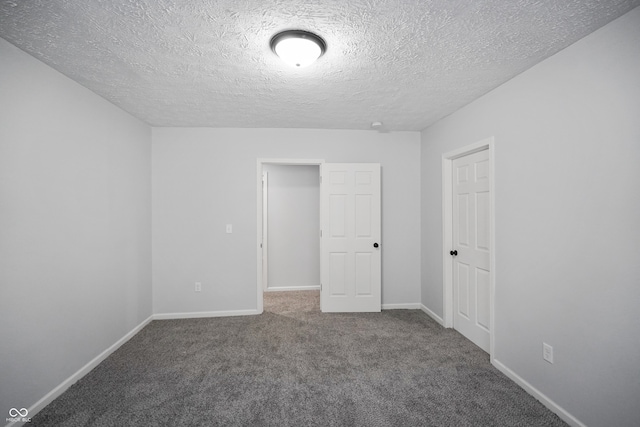 unfurnished bedroom with a textured ceiling and carpet