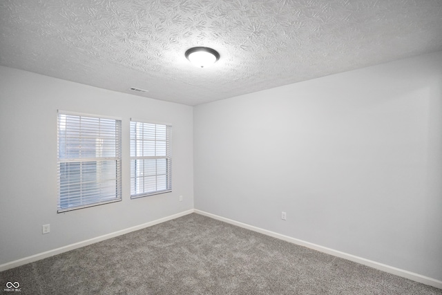 empty room featuring carpet and a textured ceiling