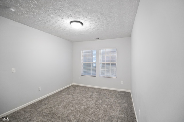 carpeted spare room featuring a textured ceiling