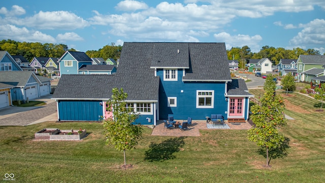 rear view of house featuring a patio, a yard, and a fire pit