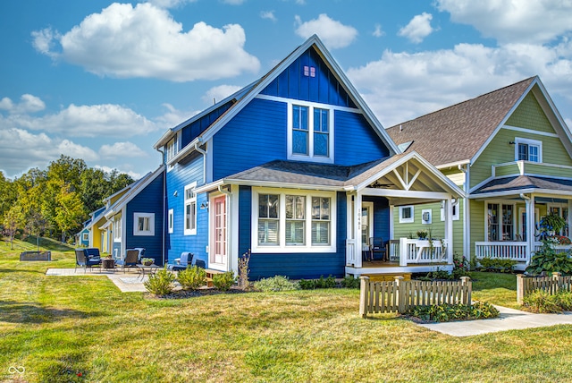 view of front of property with covered porch, a front lawn, and a patio area