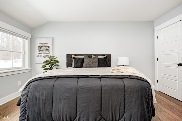 bedroom featuring hardwood / wood-style flooring and lofted ceiling