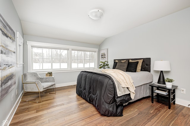 bedroom featuring hardwood / wood-style flooring and vaulted ceiling