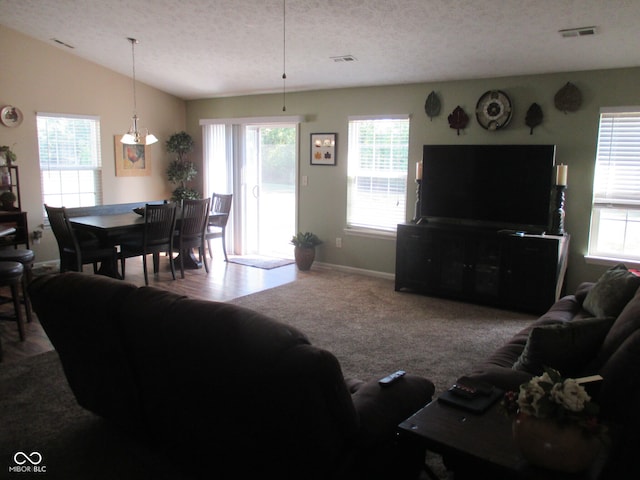 carpeted living room with a textured ceiling and vaulted ceiling