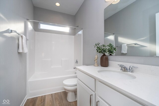 full bathroom featuring hardwood / wood-style floors, shower / bath combination, toilet, and vanity