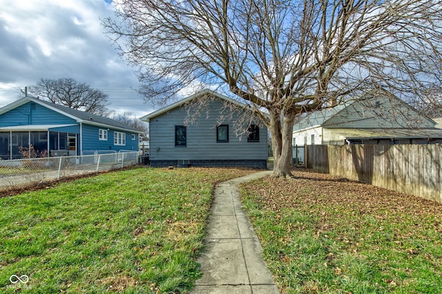 view of home's exterior with a lawn and a sunroom