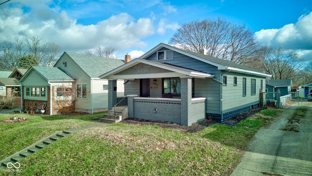 view of front of house with covered porch and a front lawn