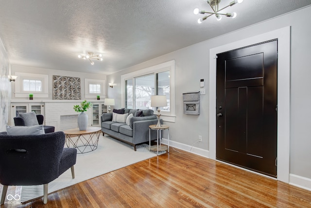 living room with a notable chandelier, wood-type flooring, and a textured ceiling