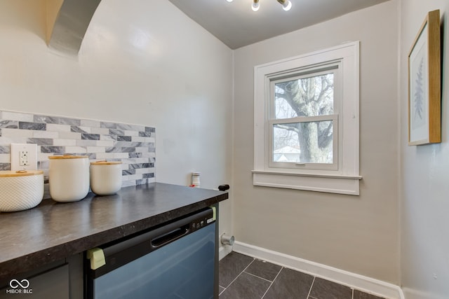 interior space featuring dishwasher, backsplash, and dark tile patterned flooring