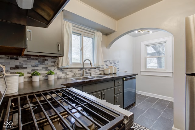 kitchen with tasteful backsplash, dark tile patterned floors, sink, dishwasher, and gray cabinets