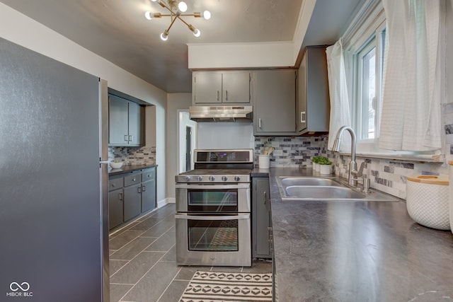 kitchen with stainless steel appliances, dark tile patterned floors, sink, a notable chandelier, and gray cabinets