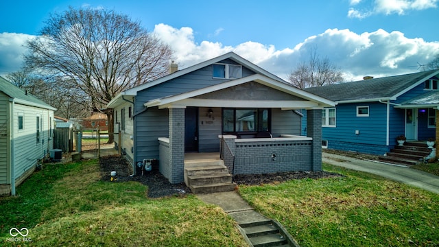 bungalow-style house featuring a porch, central air condition unit, and a front yard