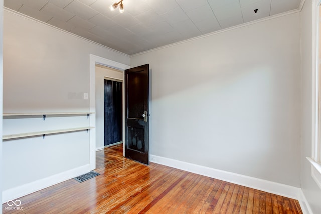 spare room featuring hardwood / wood-style floors and ornamental molding