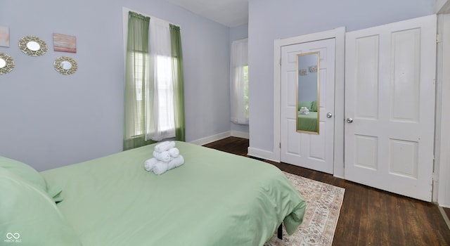 bedroom with dark wood-type flooring and multiple windows