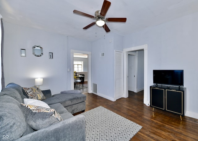 living room with ceiling fan and dark hardwood / wood-style flooring