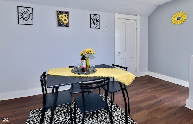 dining room featuring vaulted ceiling and dark hardwood / wood-style flooring