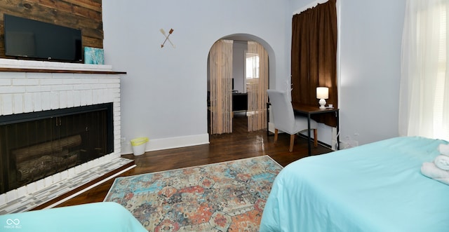 bedroom featuring a fireplace and dark hardwood / wood-style floors