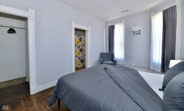 bedroom with a closet and dark hardwood / wood-style flooring