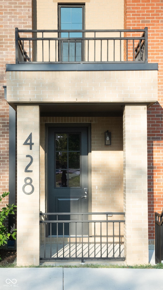 view of exterior entry featuring a balcony