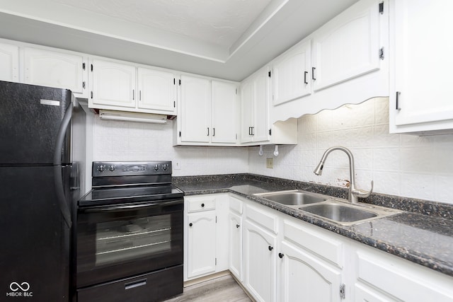 kitchen featuring tasteful backsplash, sink, white cabinets, light hardwood / wood-style flooring, and black appliances