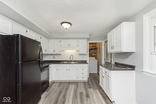 kitchen featuring washer / clothes dryer, sink, white cabinets, light hardwood / wood-style flooring, and black appliances