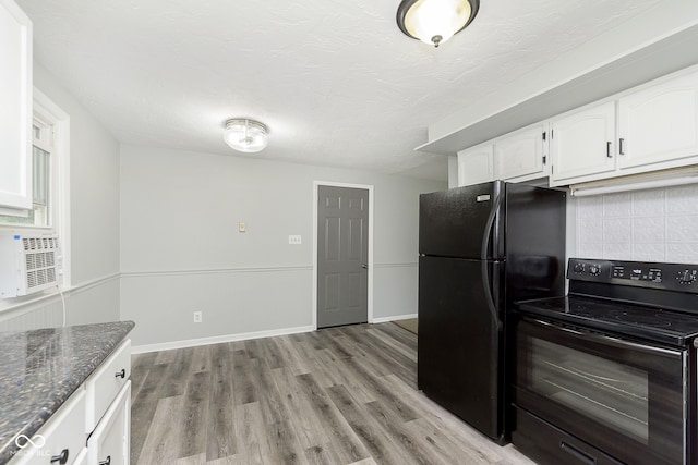 kitchen featuring dark stone counters, white cabinetry, black appliances, light wood-type flooring, and decorative backsplash