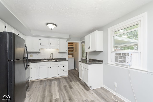 kitchen with washer / clothes dryer, sink, white cabinets, and black refrigerator