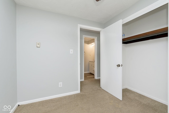 unfurnished bedroom with light carpet and a closet