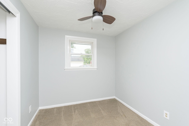 spare room with ceiling fan, a textured ceiling, and carpet