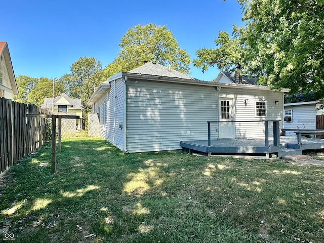 back of house featuring a lawn and a deck