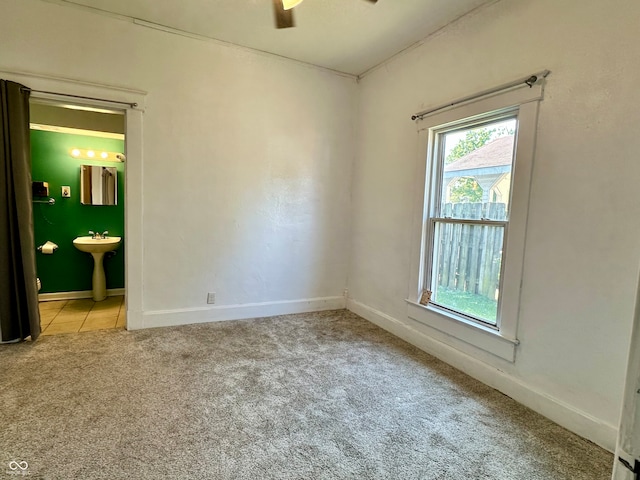 carpeted empty room with ceiling fan and sink