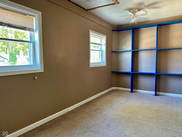 carpeted spare room featuring ceiling fan