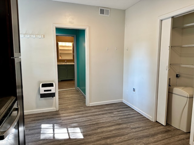 hallway with dark hardwood / wood-style flooring and heating unit