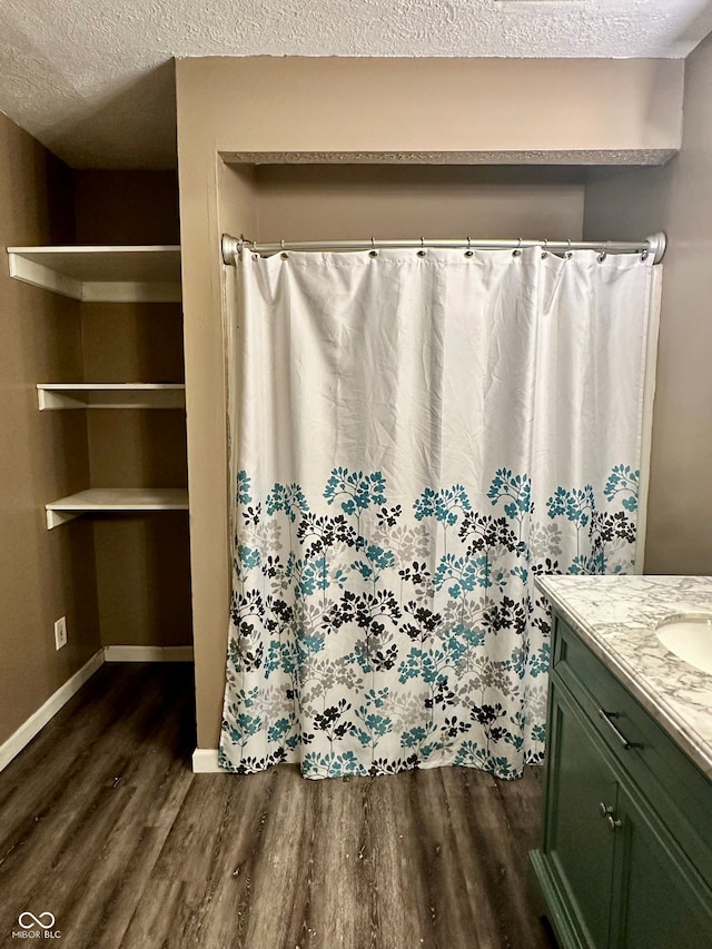 bathroom with hardwood / wood-style floors, vanity, and a textured ceiling